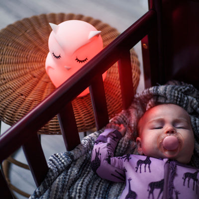 LumiPet Owl beside crib with baby sleeping.